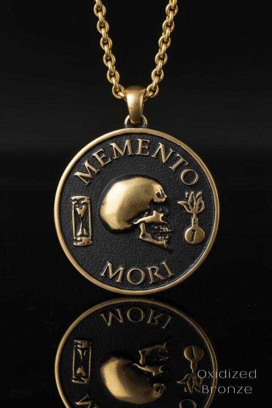 a pendant with a gold-colored metal design, including a skull and a flower, against a black background.