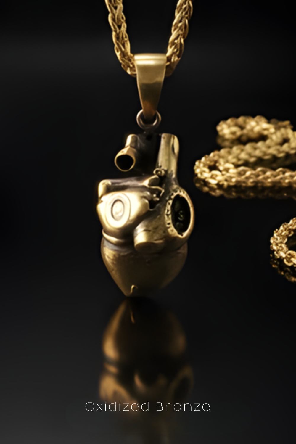 A close-up view of a gold-colored pendant with an intricate design, suspended from a chain against a dark background.