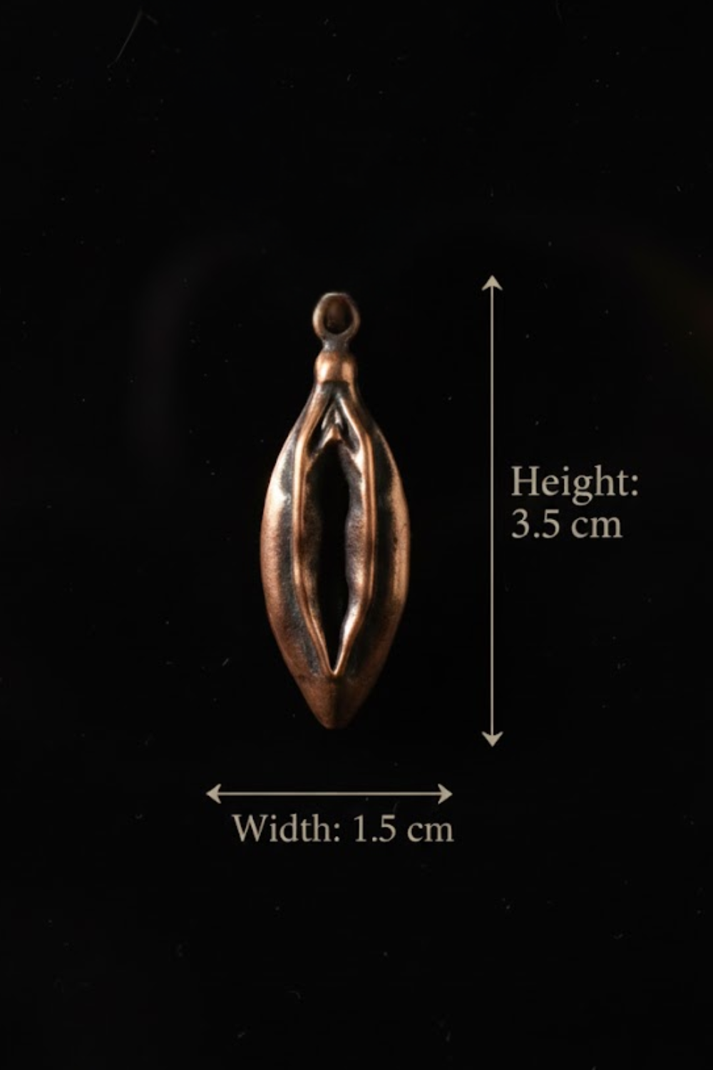 a small, copper-colored pendant or charm with a measurement scale indicating its height and width.