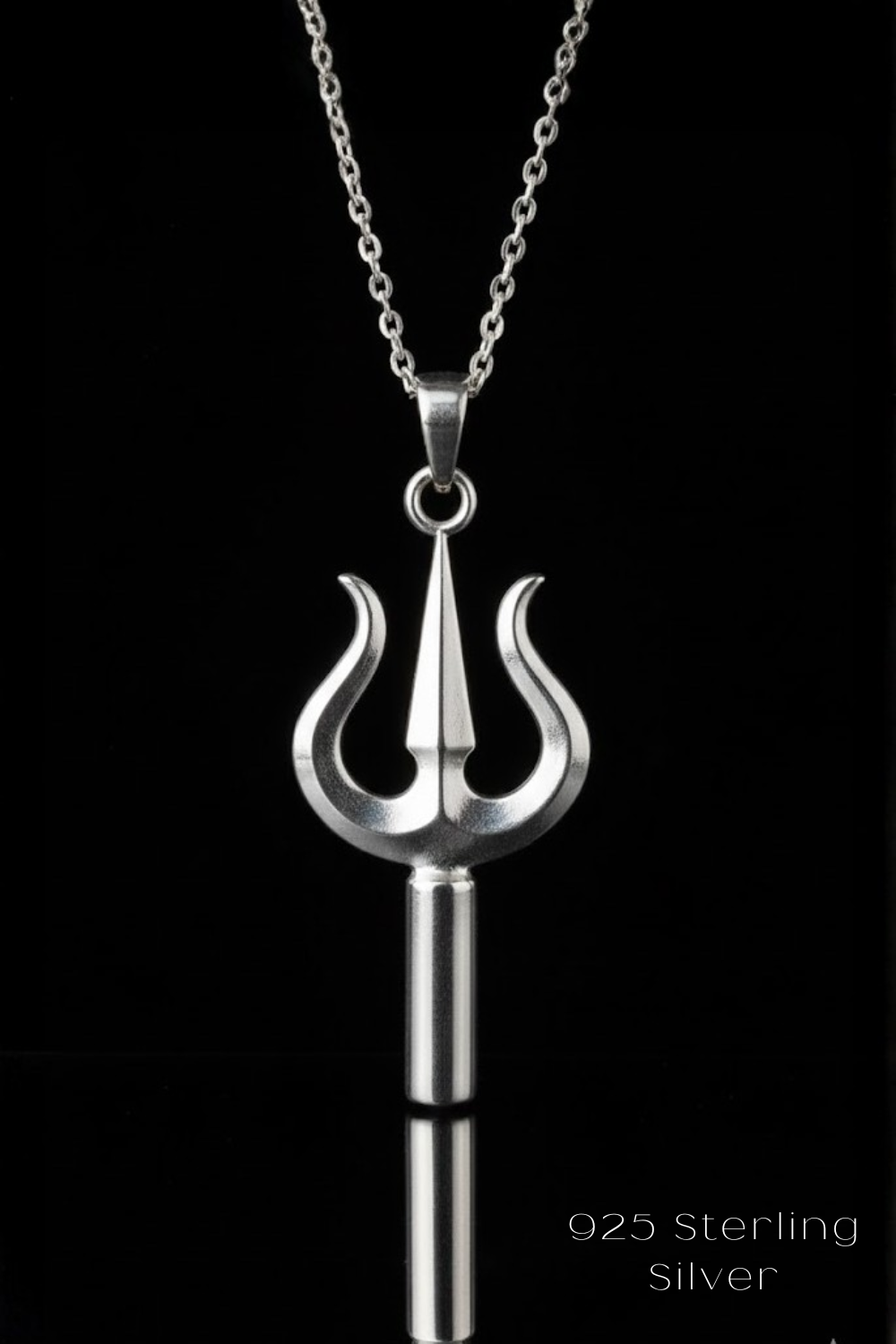 A silver necklace pendant with a trident-like design, suspended from a chain against a black background.