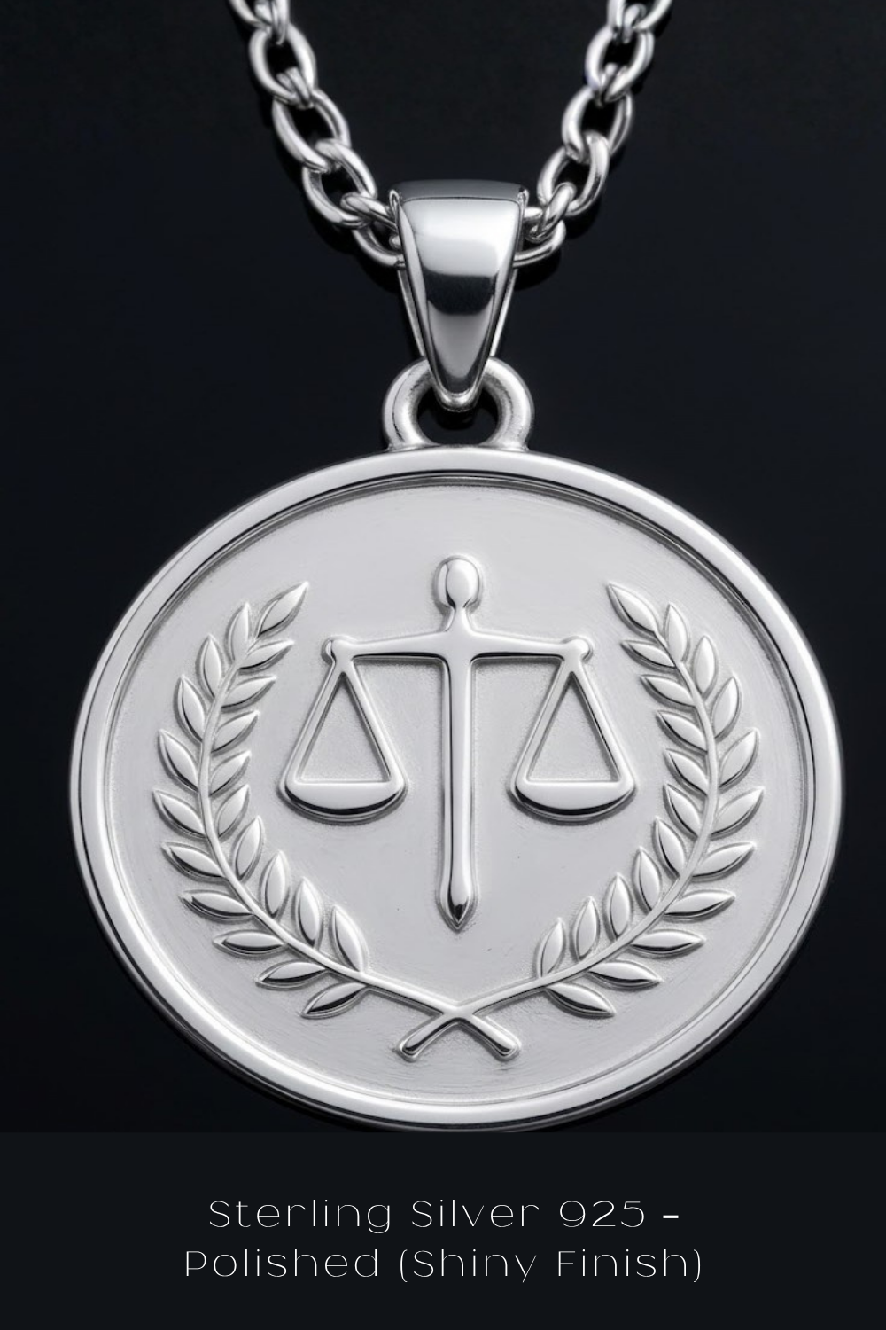 A silver pendant necklace with a round medallion featuring a scale of justice symbol and laurel leaves.