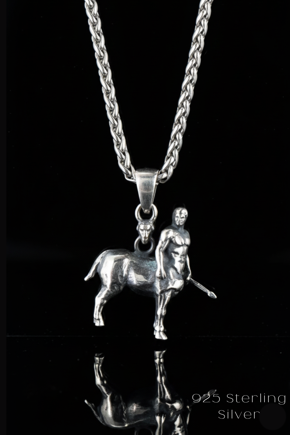 A silver necklace pendant featuring a small metal figure of a man standing next to a metal horse.