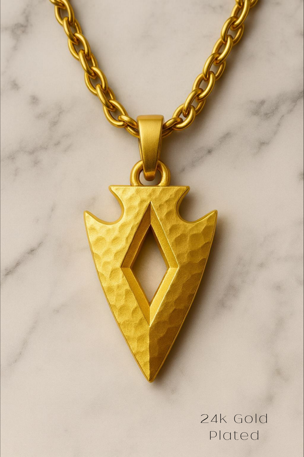 A 24k gold plated pendant in the shape of an arrow on a chain.