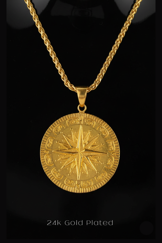 A 24k gold plated pendant necklace with a large circular medallion featuring a compass design.