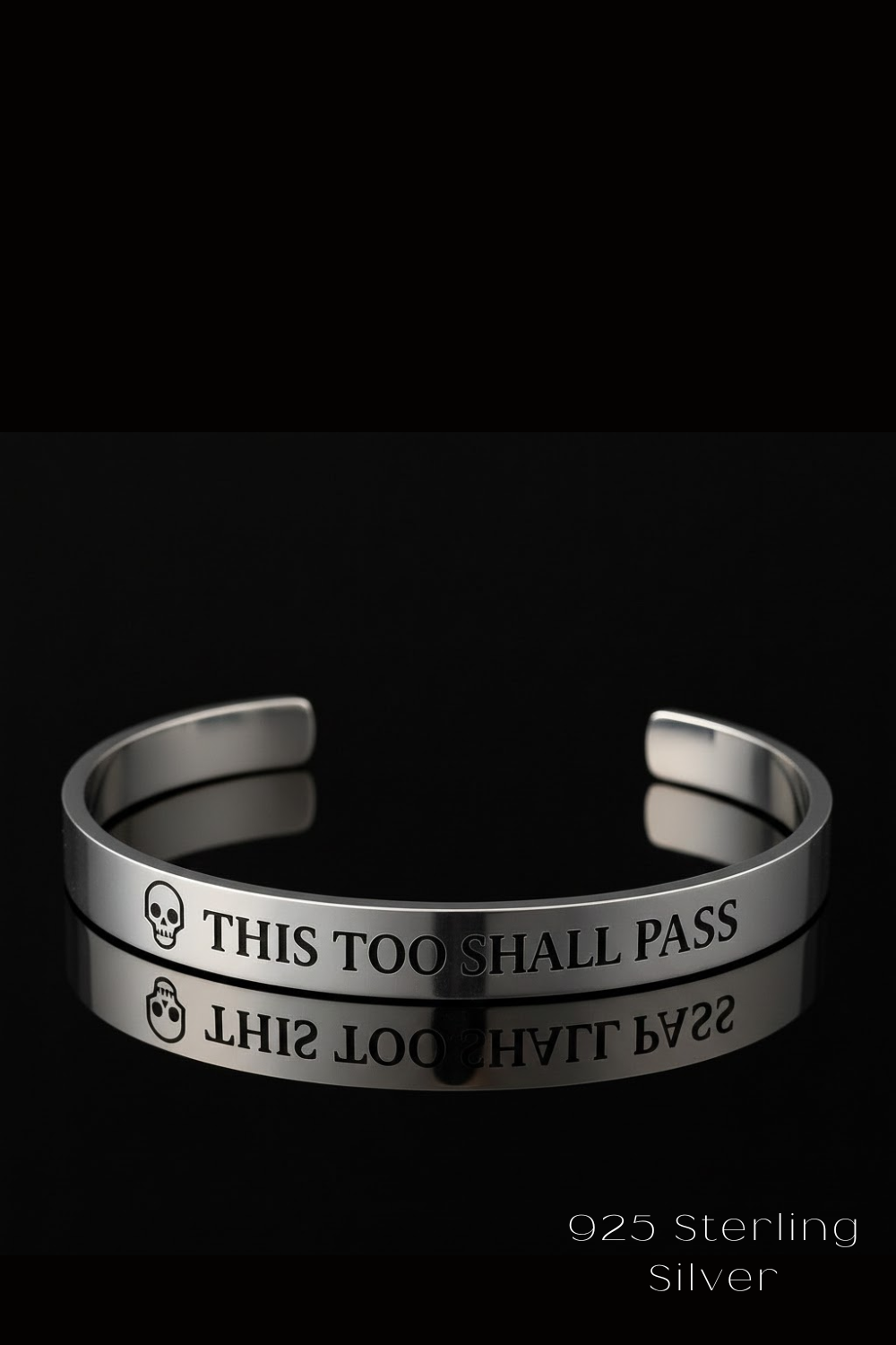 A silver bracelet with the text "THIS TOO SHARE PASS" engraved on it, against a black background.