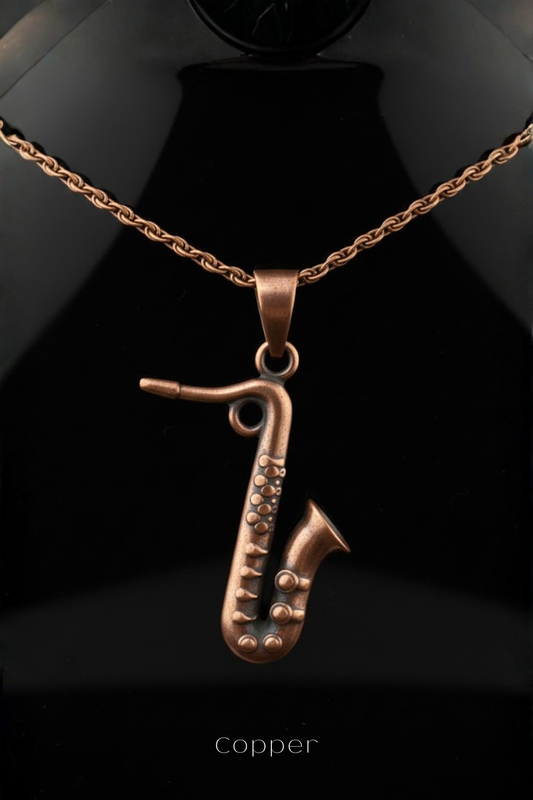 A copper-colored pendant in the shape of a saxophone is displayed against a black background.