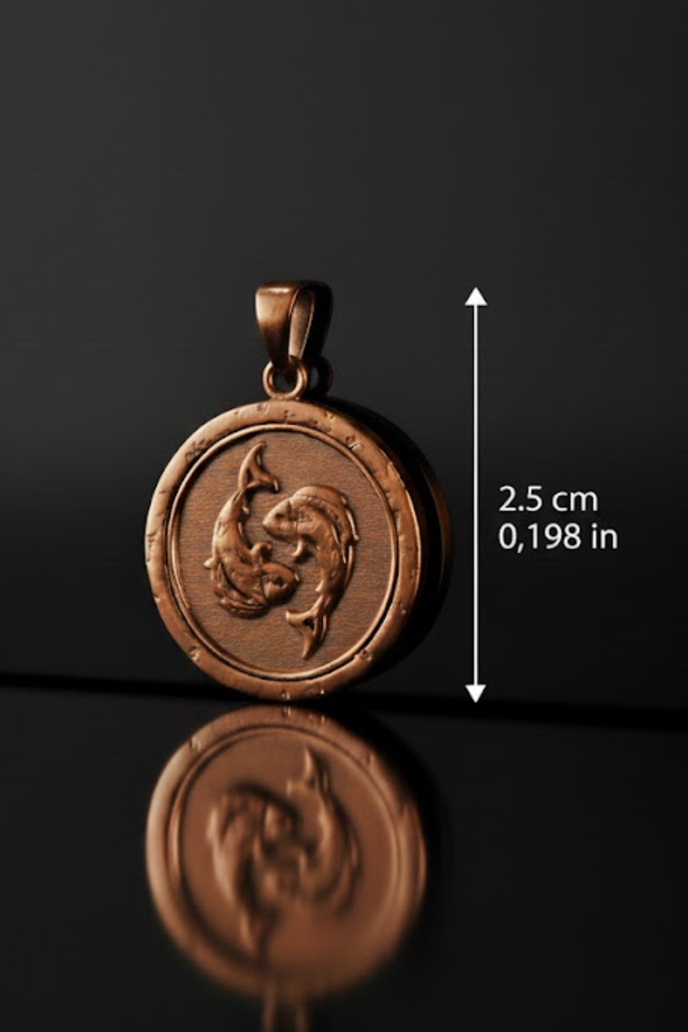 A copper-colored pendant with a circular design featuring two fish, possibly a mermaid or sea creature, is shown against a black background.