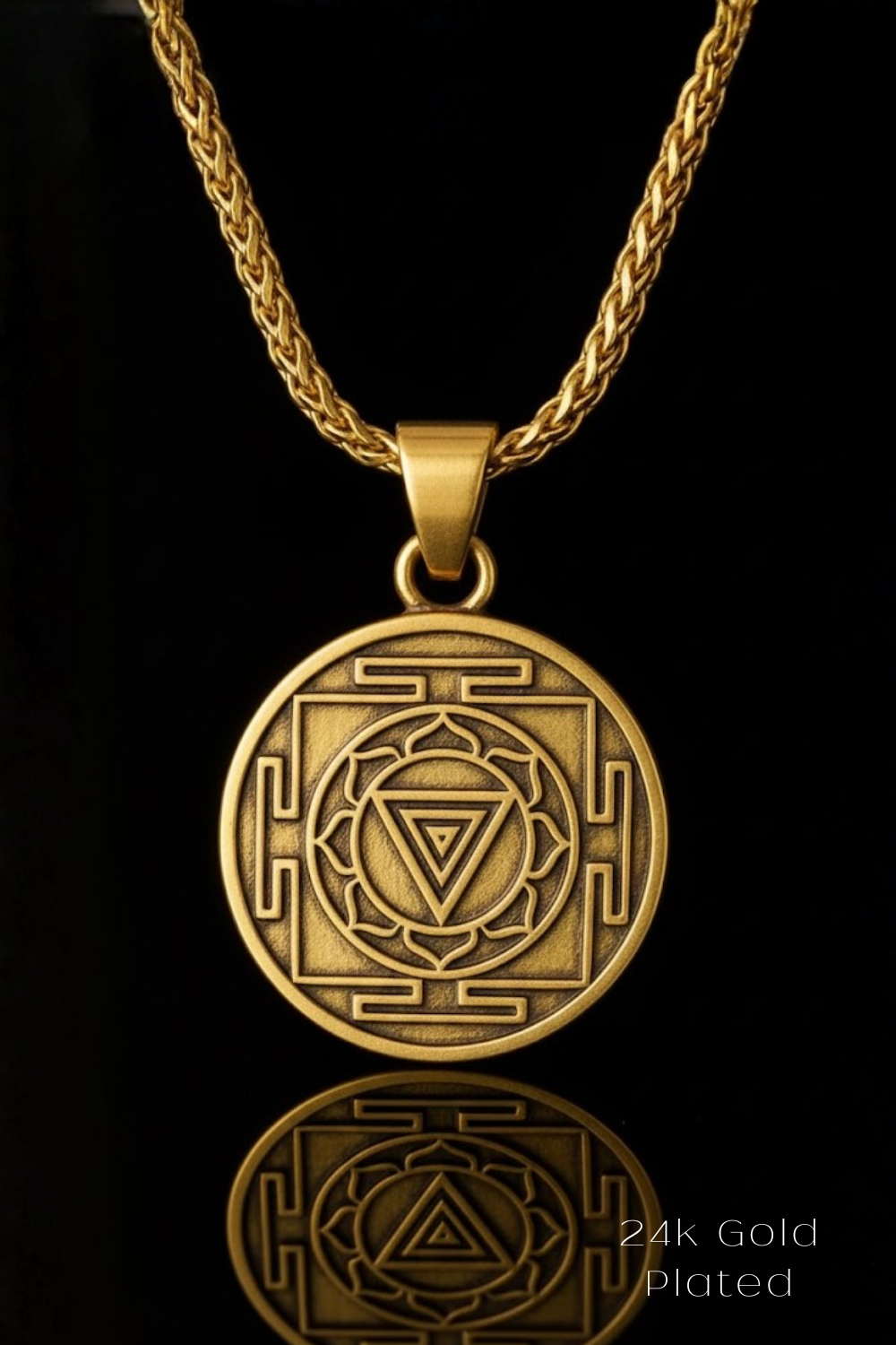 A gold-colored pendant necklace with a circular medallion featuring an intricate design, including a triangle and a lotus flower motif.