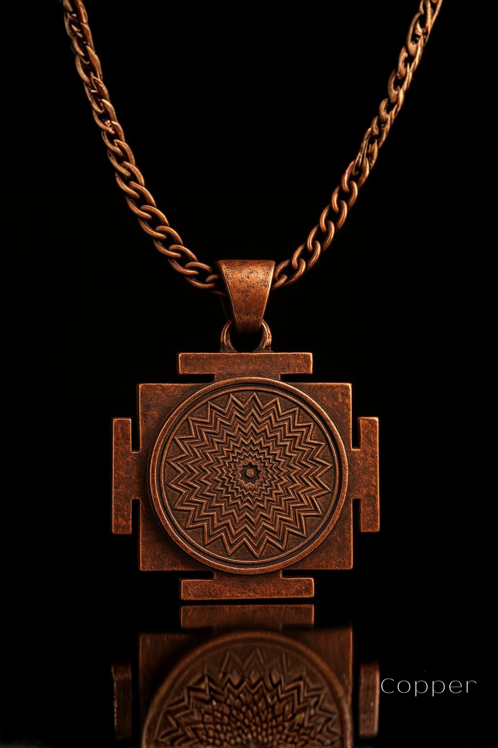 A copper-colored pendant necklace with a circular medallion featuring a zigzag design in the center.