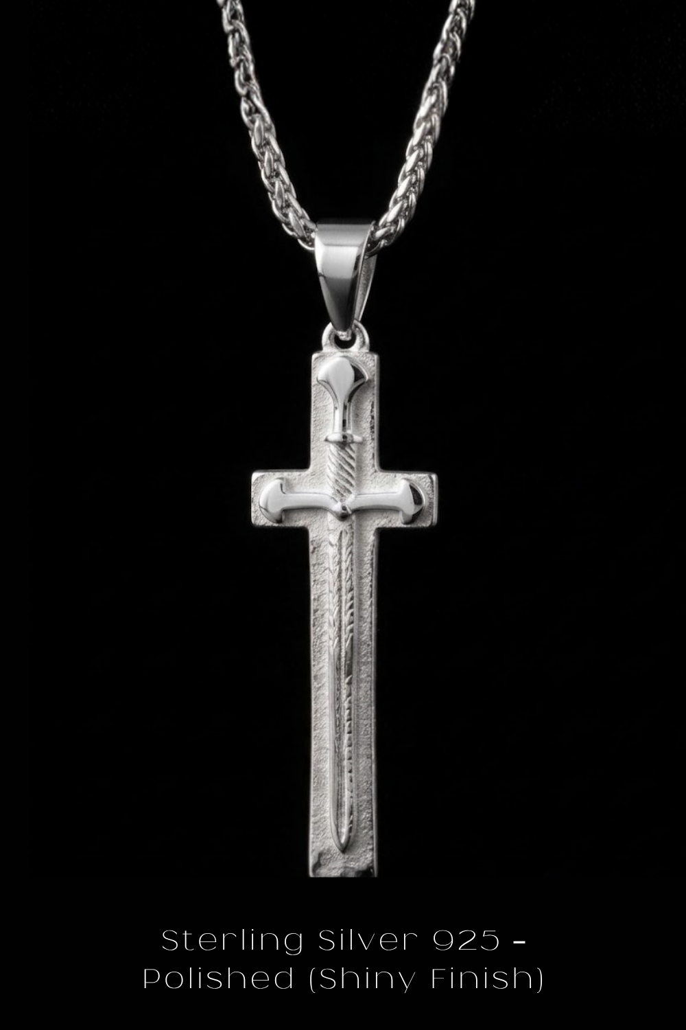 A silver cross pendant with a polished finish, set against a black background.