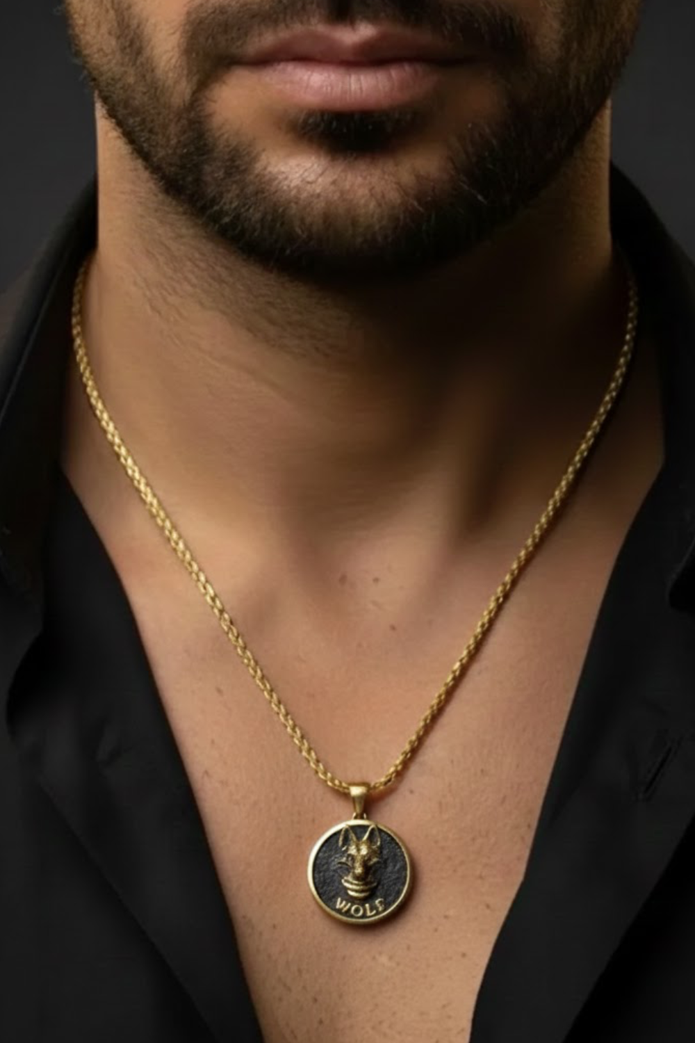 A close-up of a man's neck and chest area, with a gold chain necklace and a pendant featuring a wolf design.