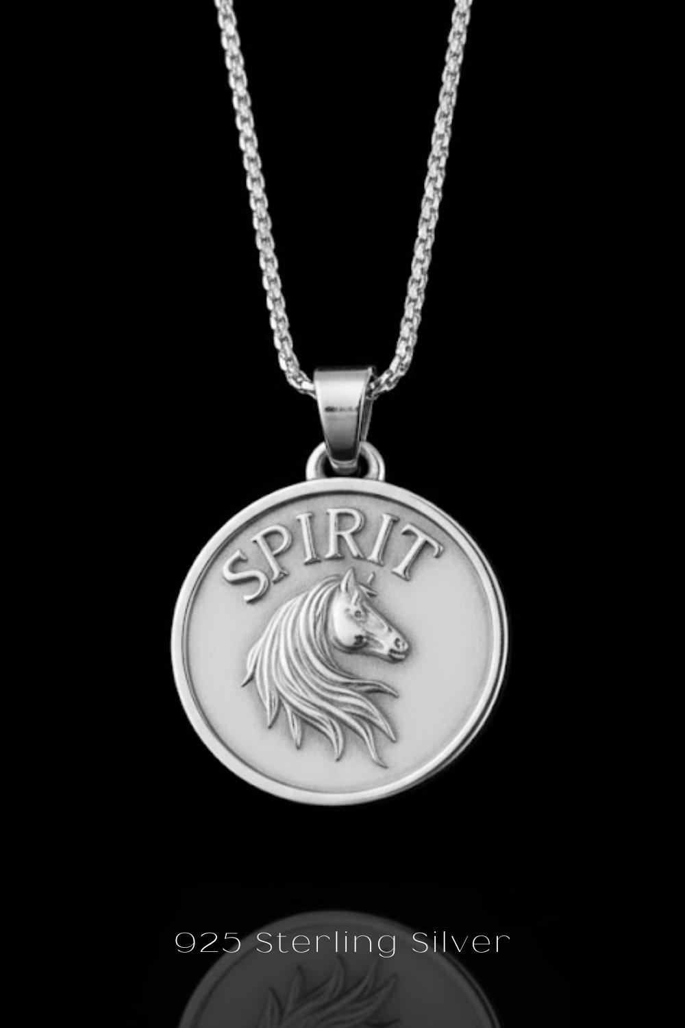 A silver-colored pendant necklace with a circular medallion featuring a horse's head and the word "SPIRIT" engraved on it.