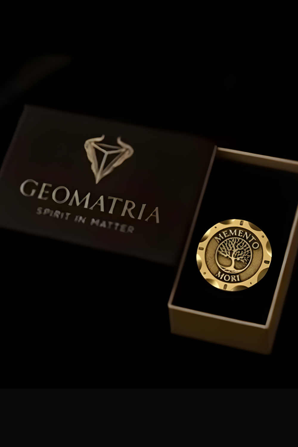 a gold-colored emblem with the inscription "MEMENIO MORI" inside a box, which is placed on a black surface.