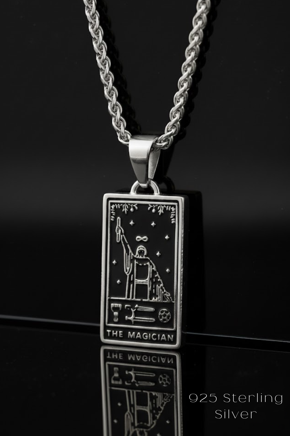 A silver-colored pendant necklace with a rectangular pendant featuring an illustration of a tarot card, specifically "The Magician".