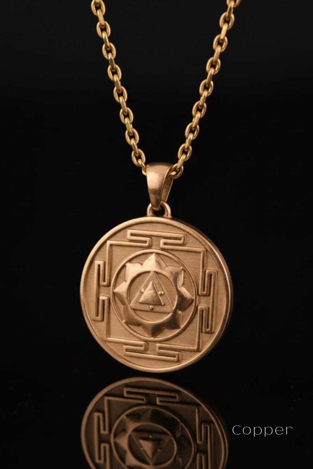 A gold-colored pendant necklace with a circular medallion featuring a geometric design and a triangle symbol.