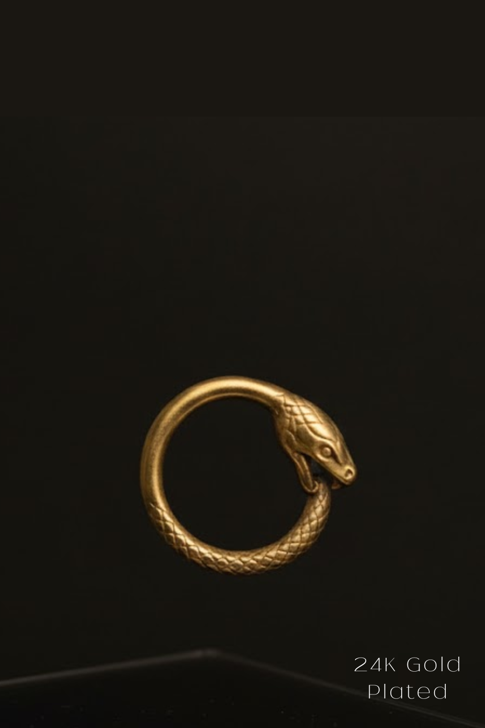 A 24K gold-plated snake ring is shown against a black background.