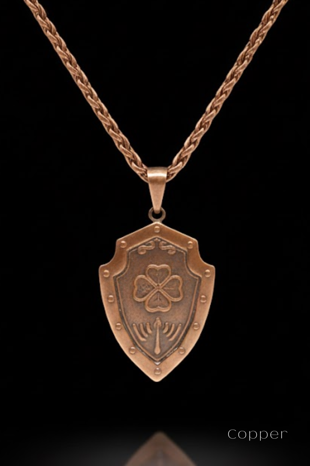A copper-colored pendant necklace with a shield-shaped pendant featuring a four-leaf clover design.
