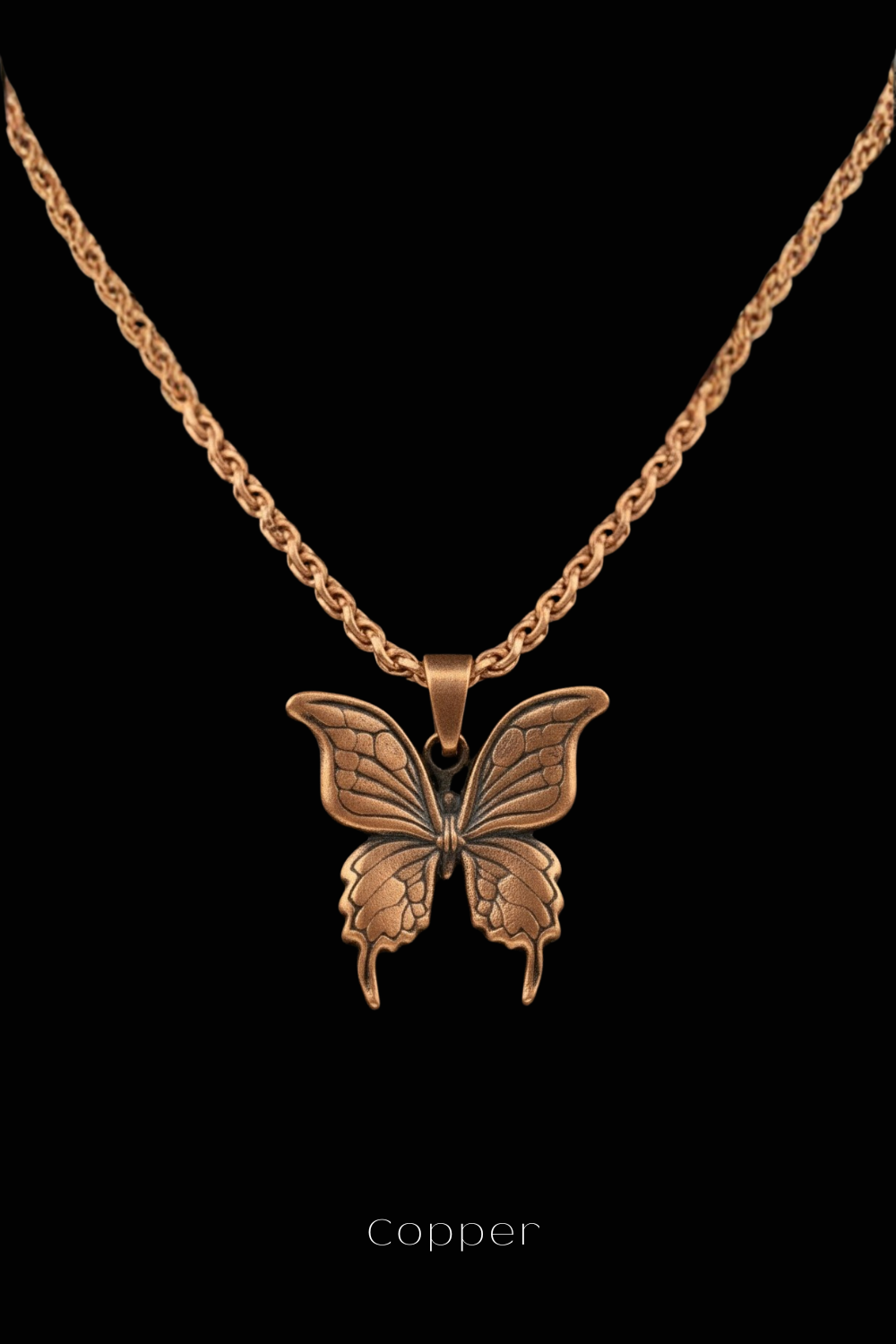 A copper-colored pendant in the shape of a butterfly is displayed against a black background.