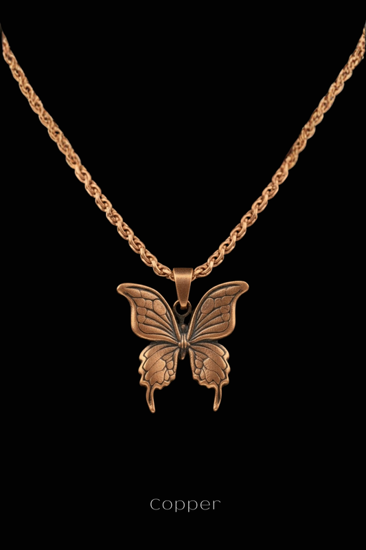A copper-colored pendant in the shape of a butterfly is displayed against a black background.