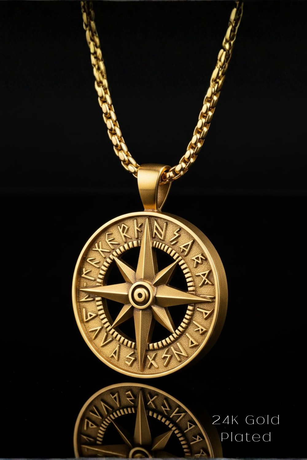 A 24K gold-plated pendant necklace with a compass design on a black background.