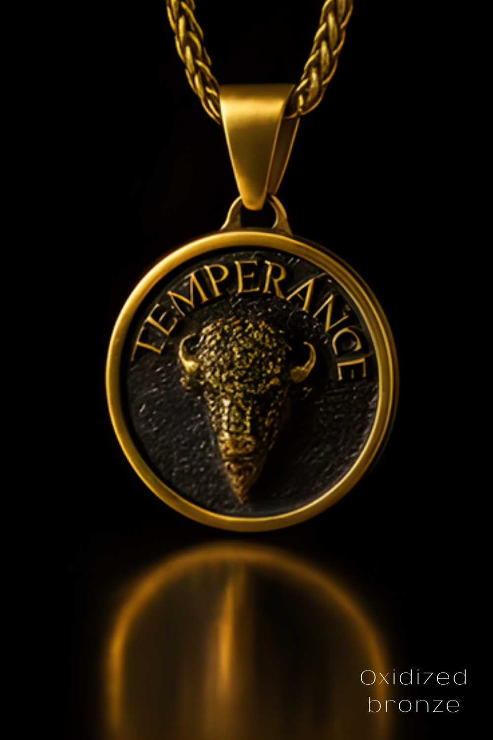 A gold-colored pendant with a bull's head design, featuring the word "TEMPERANCE" inscribed on it.