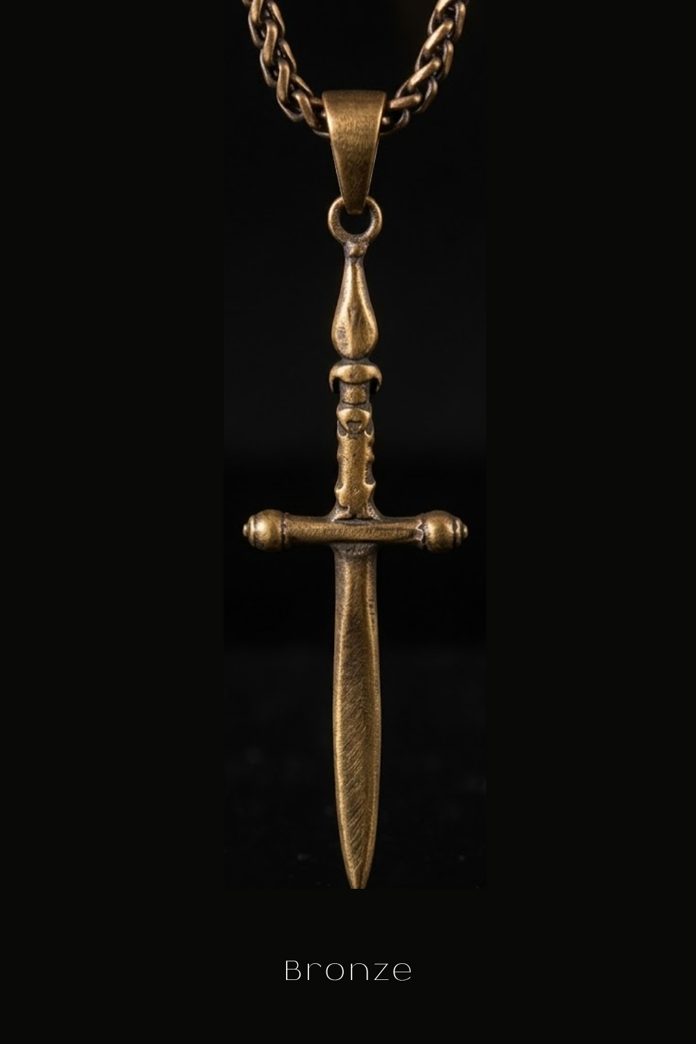 A close-up view of a bronze-colored pendant featuring a cross-shaped design with a pointed tip and two small round centers.