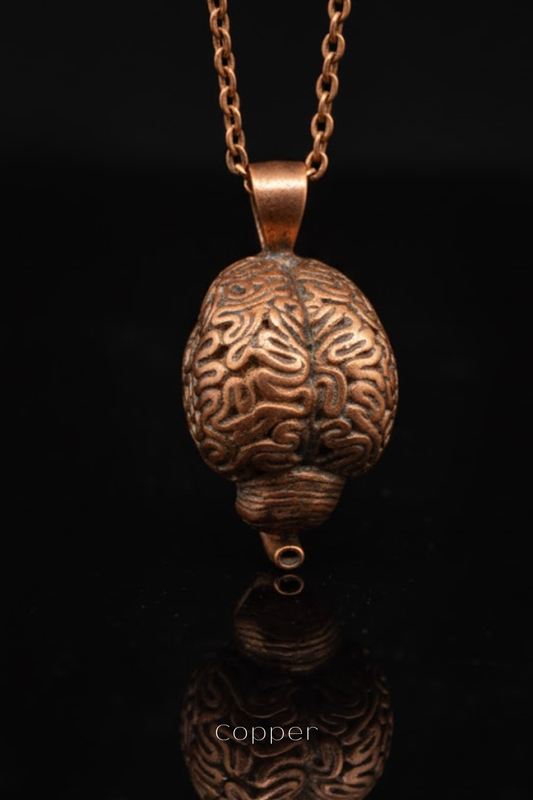 A copper-colored pendant in the shape of a brain, suspended from a chain against a black background.