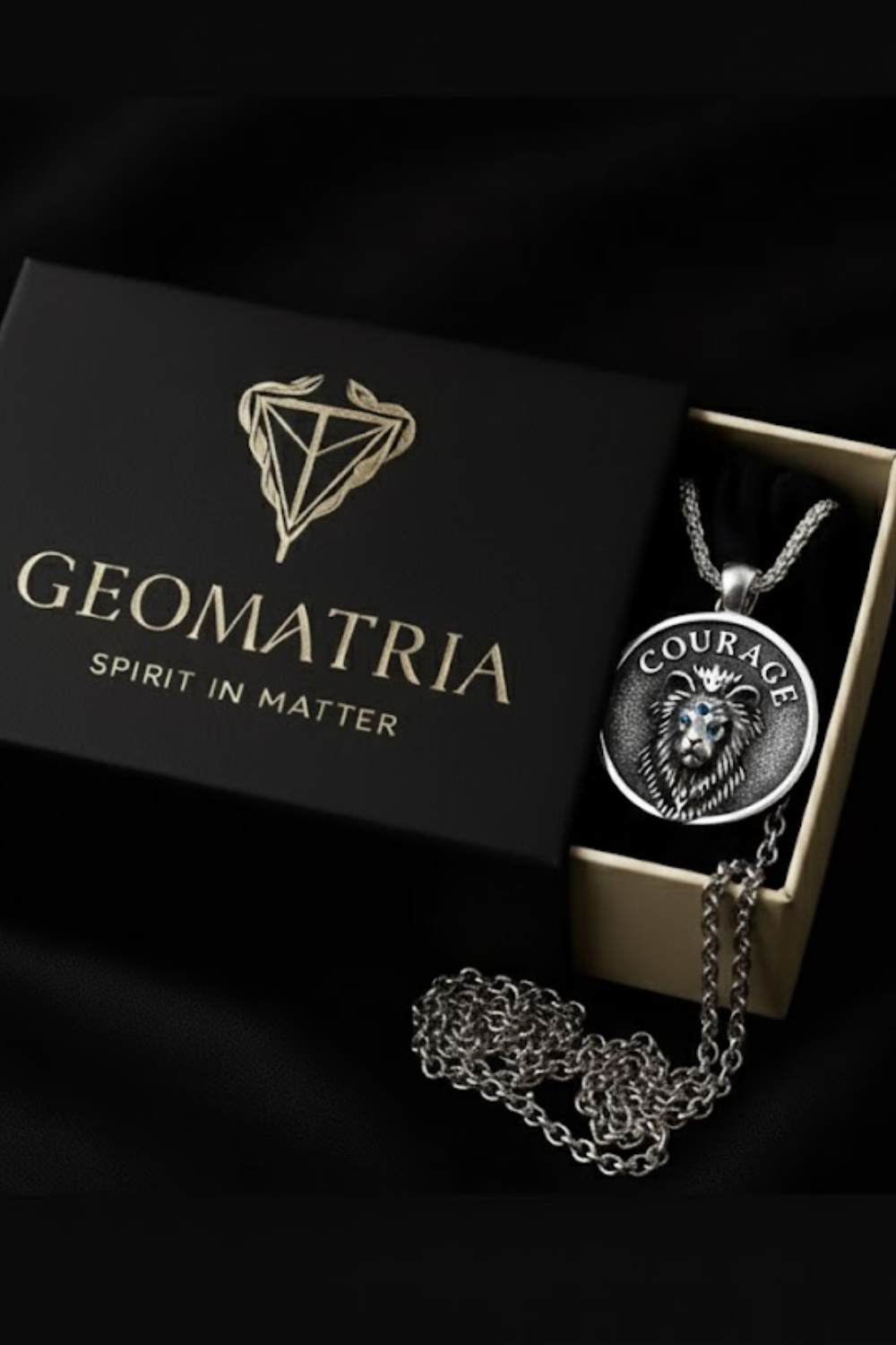 A necklace with a pendant featuring a lion's head design, placed inside a black box with the word "Geomatria" printed on it.
