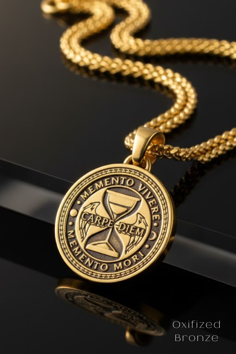 A gold-colored pendant necklace with a circular medallion featuring the Latin motto "Memento vivere" and the words "Carpe diem" and "Memento mori".