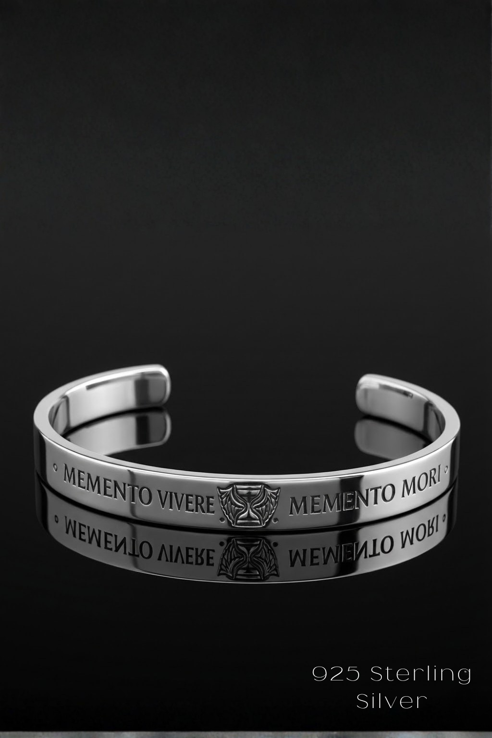 A silver bracelet with the engraved phrase "MEMENTO VIVERE MEMENTO MORI" on it, which means "Life begins" in Latin. The bracelet is displayed against a black background, and the image is described as a "925 Sterling Silver" bracelet.