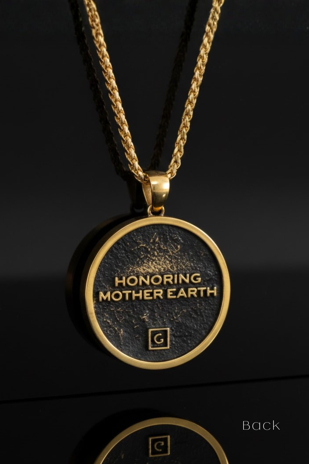 A gold-colored pendant necklace with a circular pendant featuring the text "HONORING MOTHER EARTH" in gold lettering.