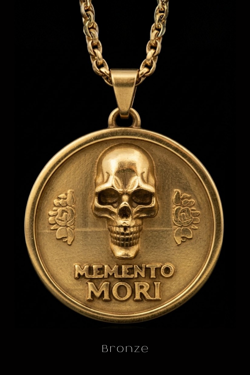 A gold-colored pendant necklace with a circular medallion featuring a skull design and the Latin phrase "Memento mori" (which means "Remembering the dead" in English).