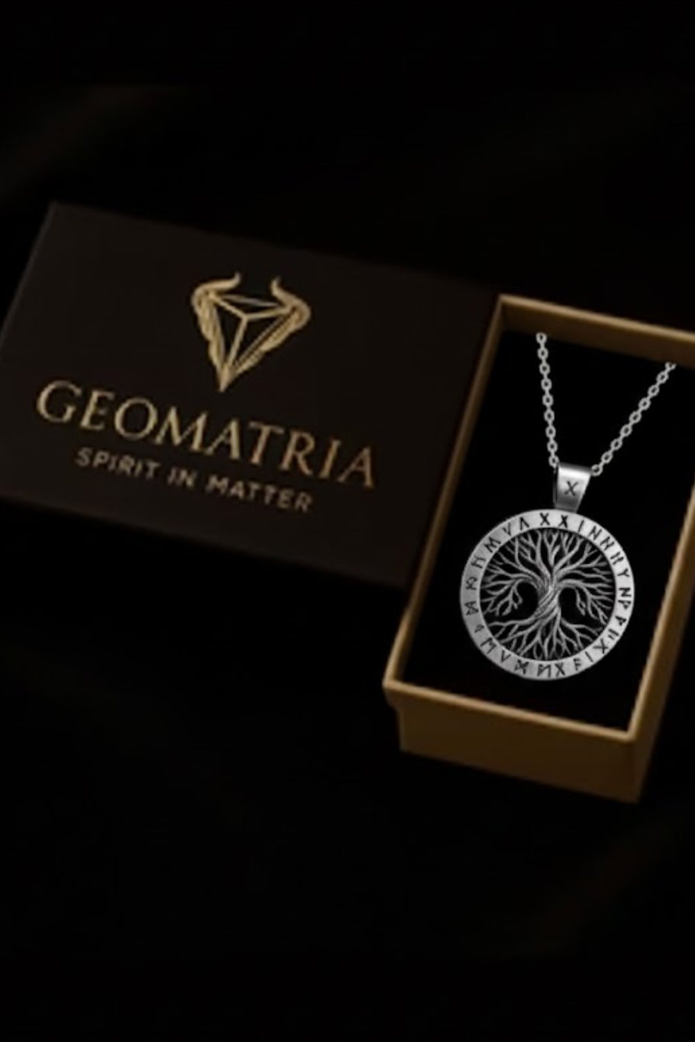 A necklace with a pendant is displayed in a box, accompanied by the text "Geomatria Spirit in Matter" on the box.