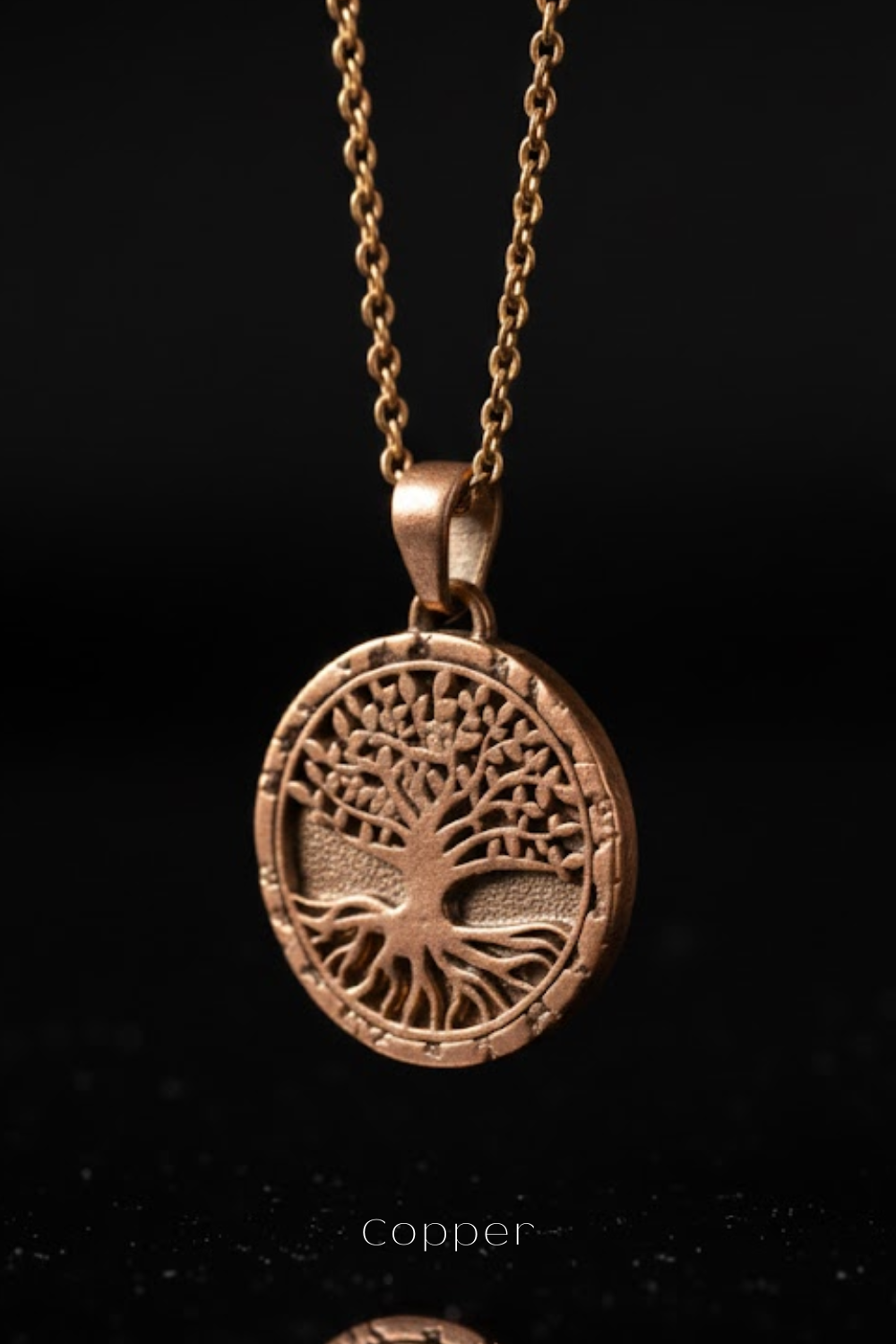 A copper-colored pendant necklace with a circular tree design on a black background.