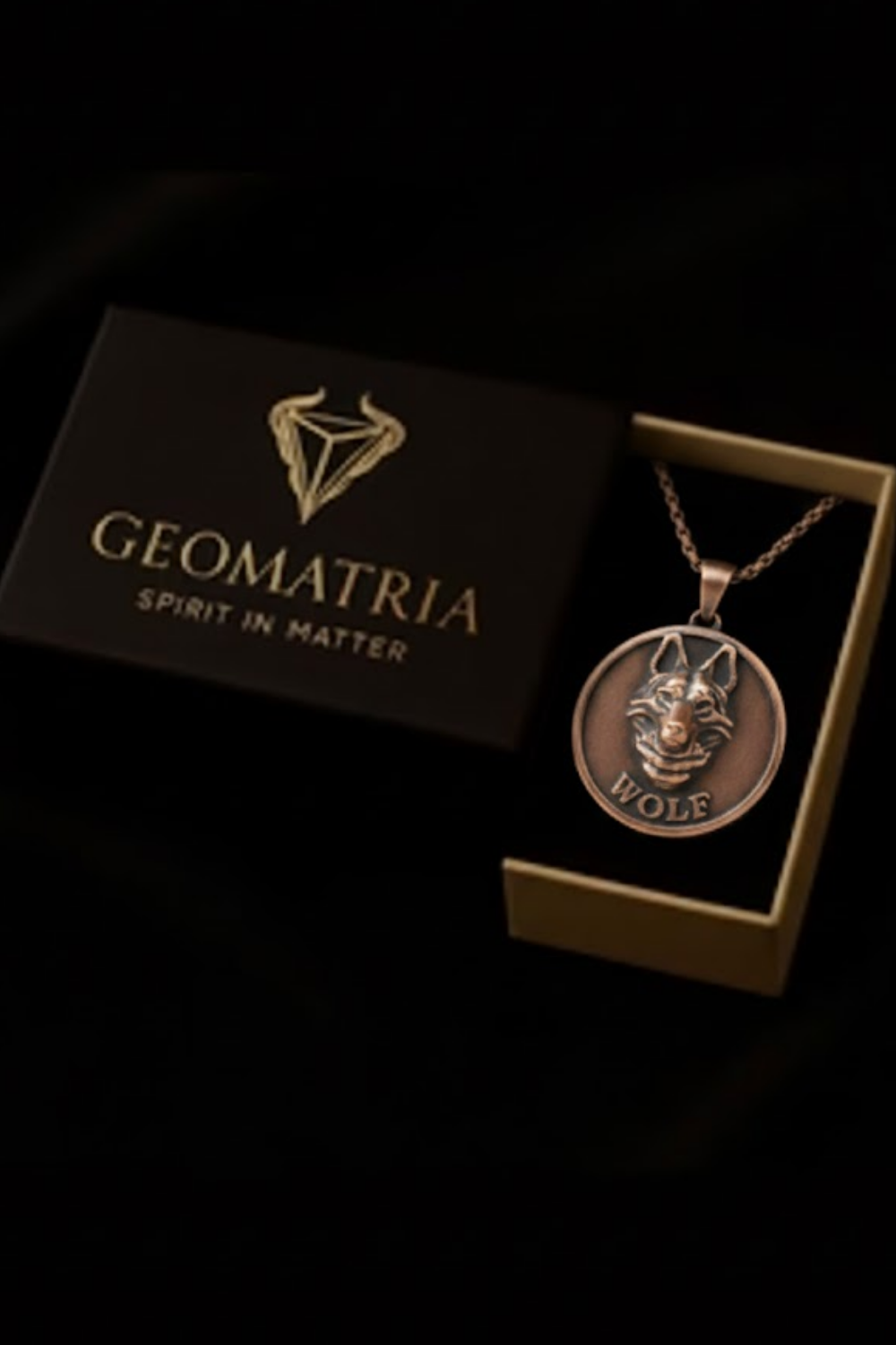 a pendant necklace with a wolf design, displayed in a black box with the brand name "Geomatria" printed on it.