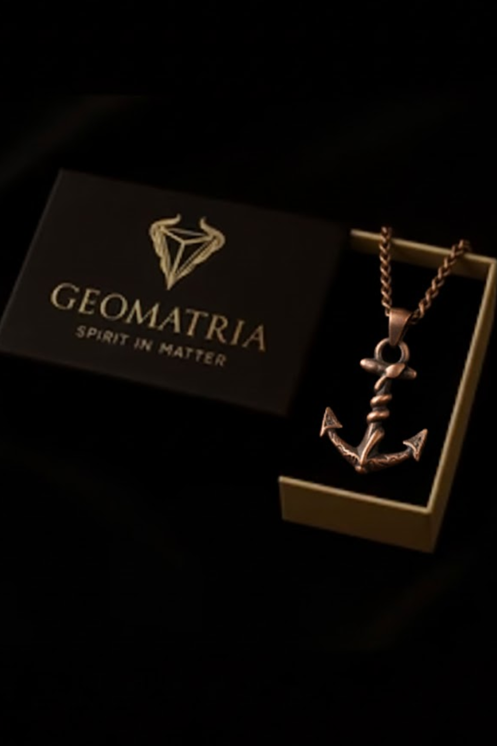 A necklace with an anchor pendant is displayed in a box with the text "Geomatria SPIRIT IN MATTERS" printed on it.
