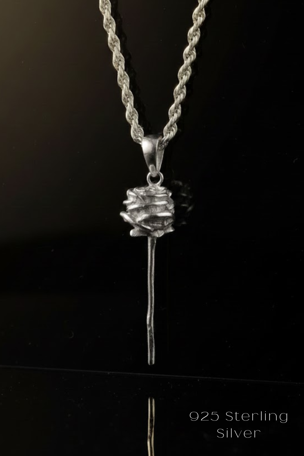 A silver necklace with a pendant featuring a flower-like design.