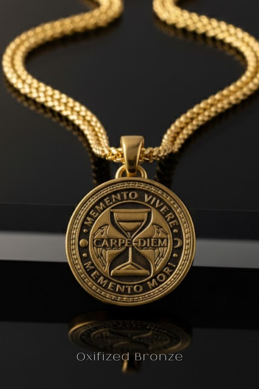An Oxfized Bronze pendant necklace with a circular medallion featuring the Latin motto "Memento Vivere" and a wine glass design.