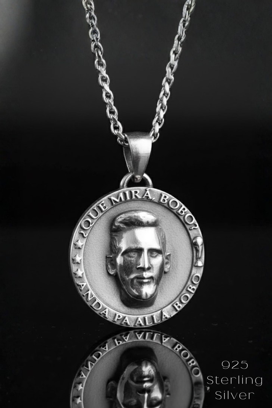 A silver pendant necklace with a circular medallion featuring a man's face.