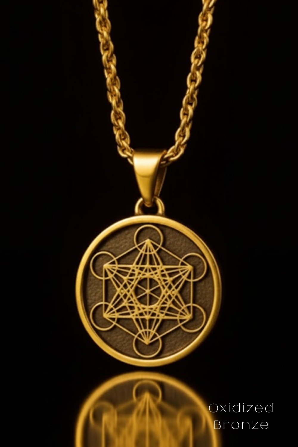 A gold-colored pendant necklace with a circular medallion featuring a geometric design, suspended from a chain against a black background.