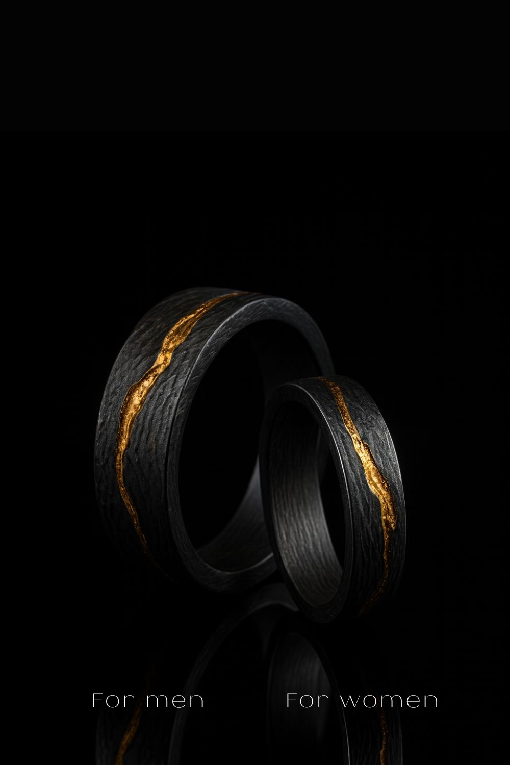 Two black rings with gold accents, one larger and one smaller, are displayed against a black background.