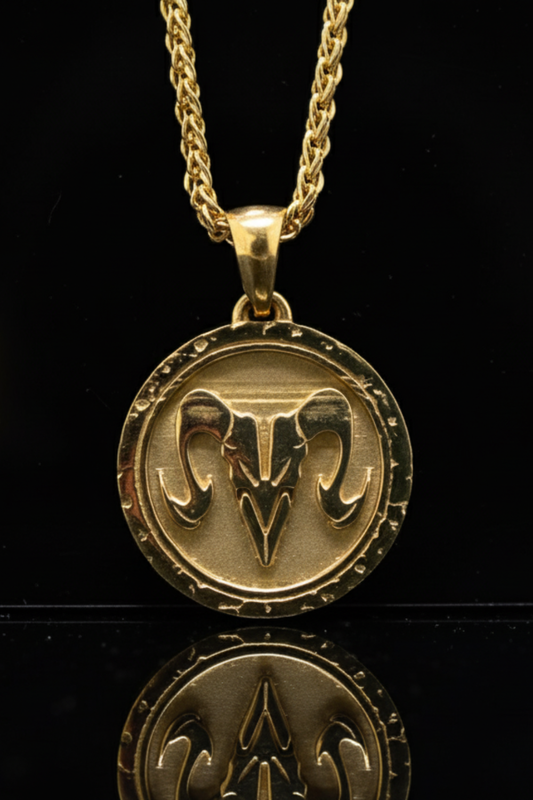 A gold-colored pendant necklace with a circular medallion featuring a ram's head design.