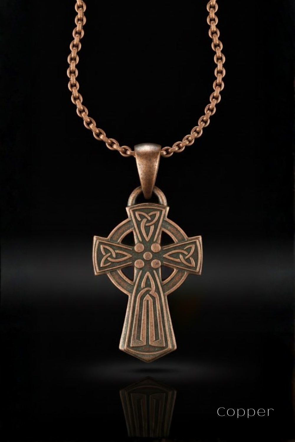 A copper-colored Celtic cross pendant is displayed against a black background, with a chain visible above it.