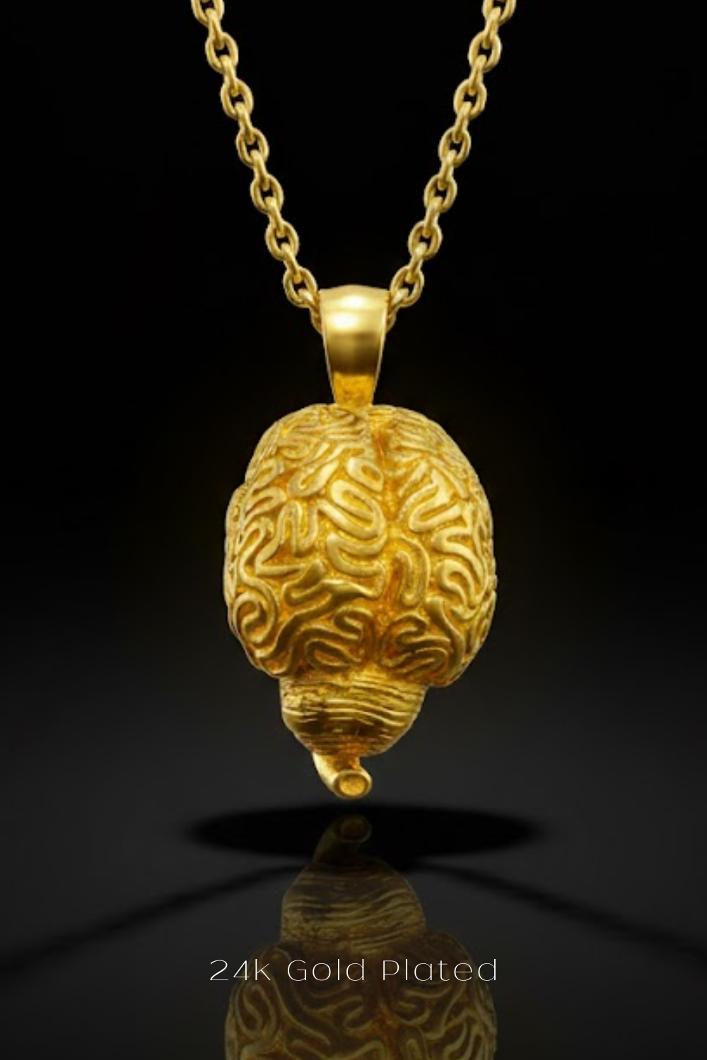 A 24K gold-plated pendant in the shape of a brain is suspended from a chain against a black background.
