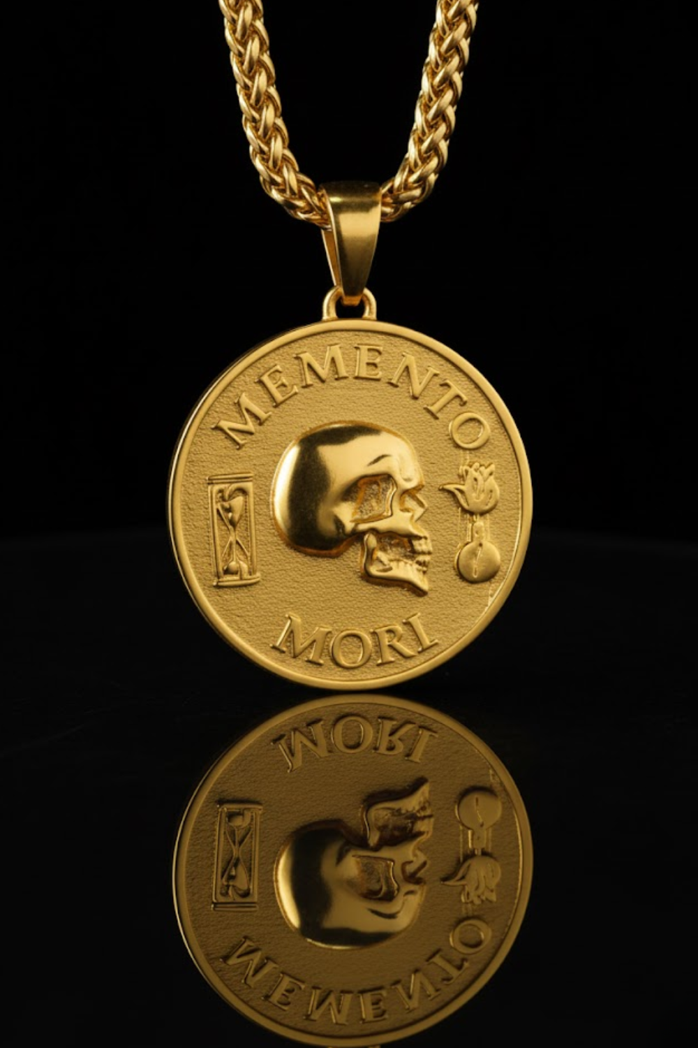 a gold-colored pendant with a skull design, accompanied by the Latin phrase "Memento mori" which translates to "Remembering the dead".