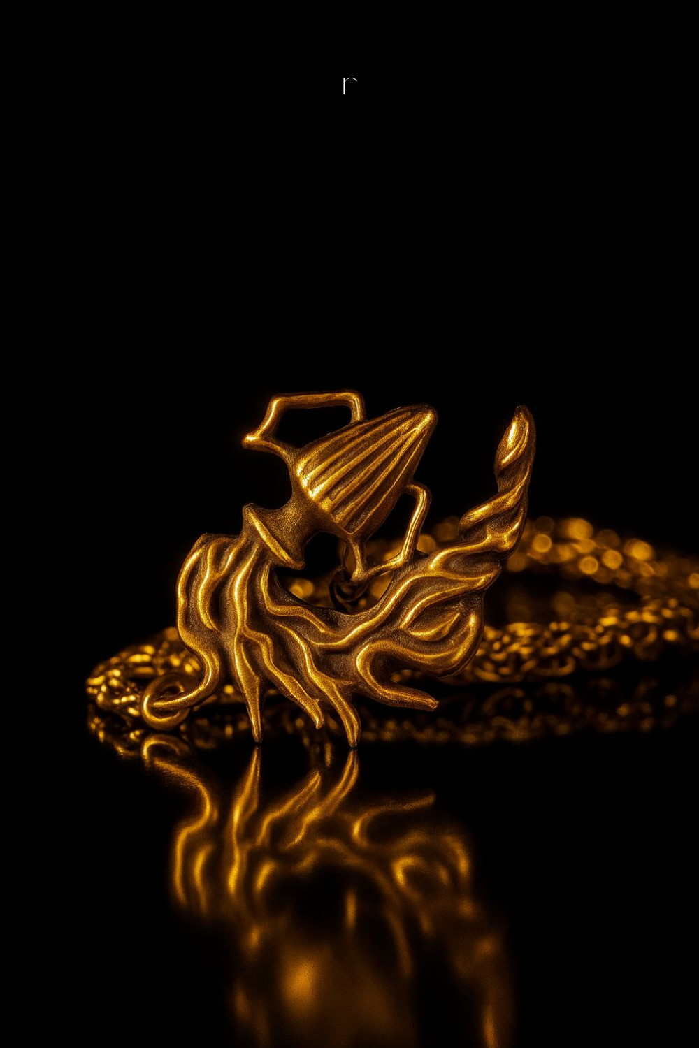 a golden, intricately designed pendant or ornament with a flame-like shape, set against a dark background.