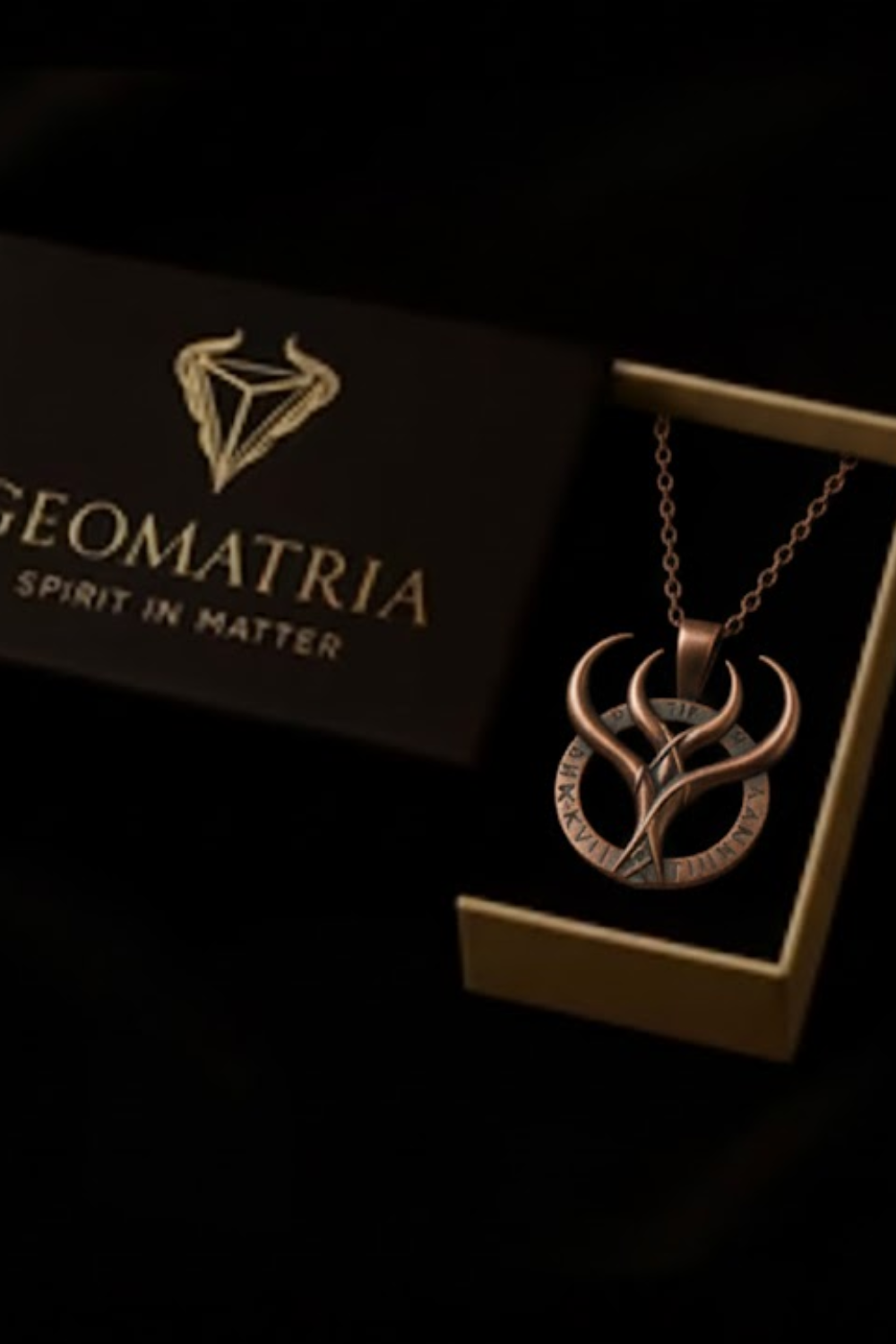 a necklace with a pendant, displayed in a box with a dark background.