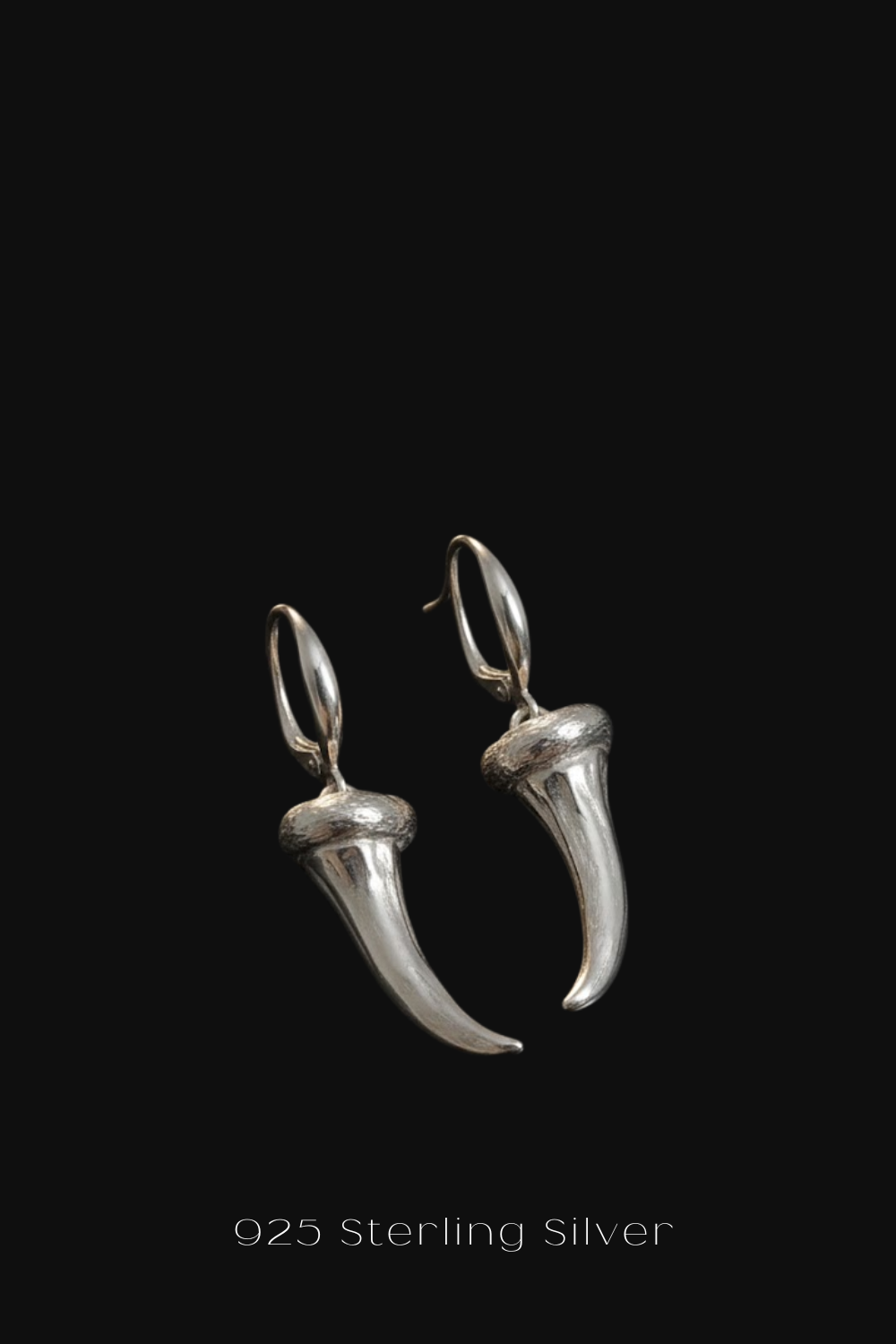 A pair of silver earrings with a pointed design, displayed against a black background.