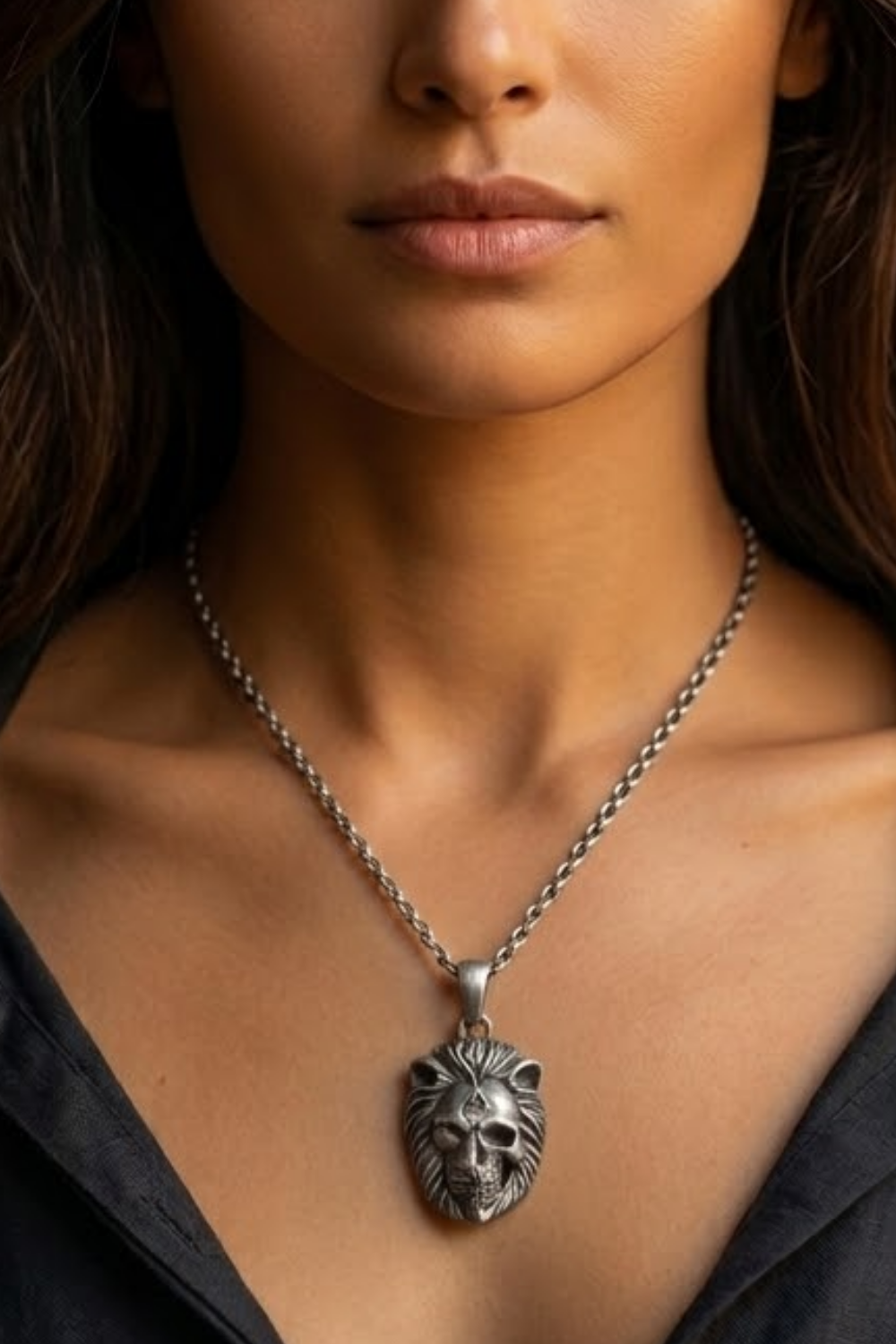A close-up of a woman's neck and chest area, with a silver pendant featuring a lion's head design hanging from a chain.