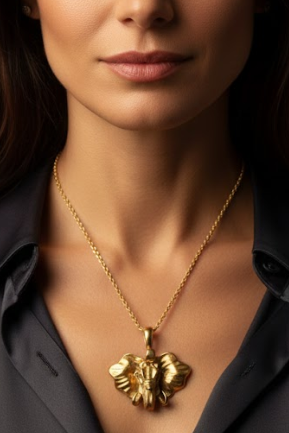 A close-up of a woman's neck and chest area, with a gold-colored pendant necklace featuring an elephant design.